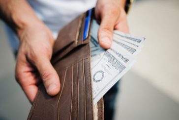 Man Holding Brown Leather Bi-fold Wallet With Money in It